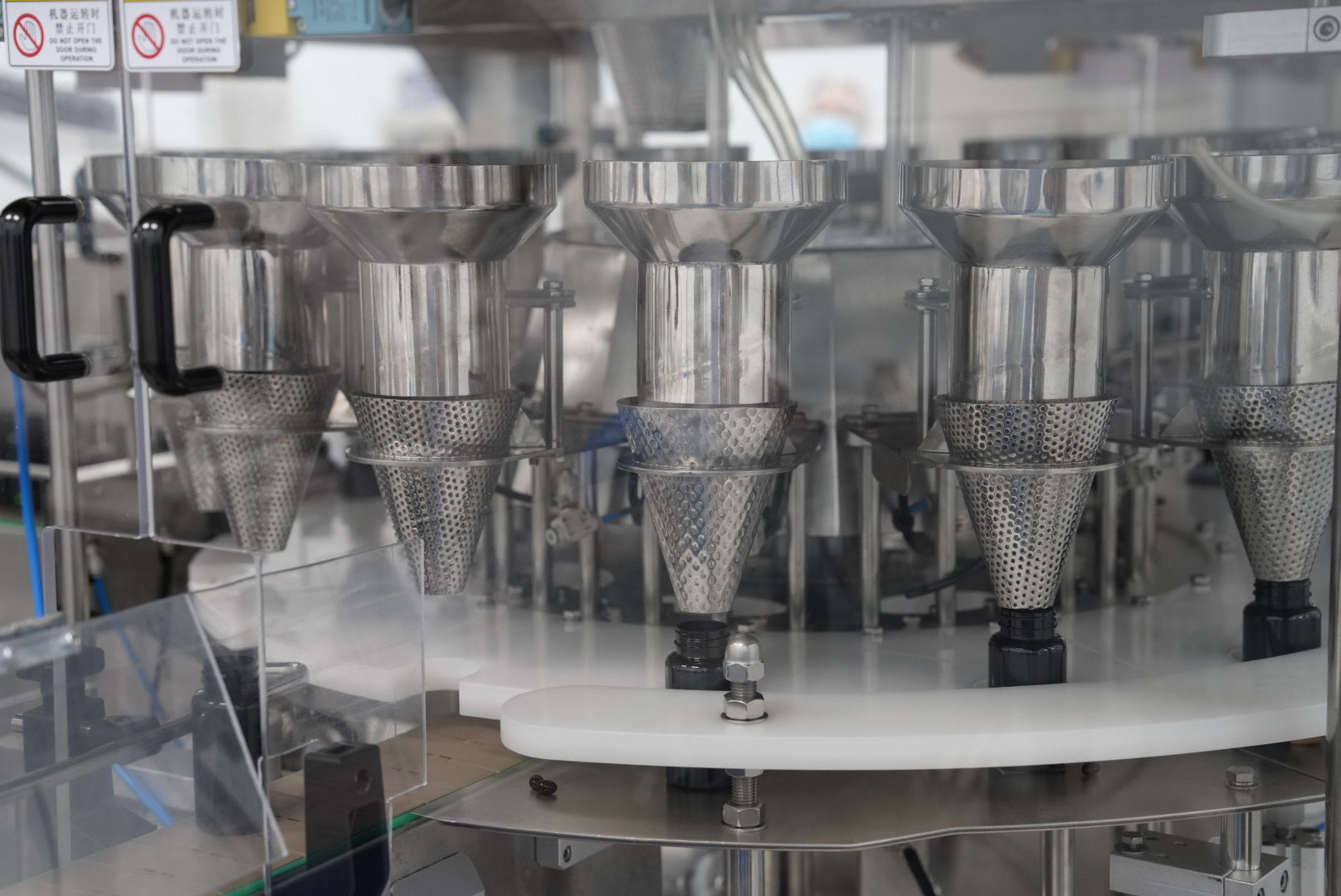 Industrial supplement manufacturing equipment filling capsules or gummies in a production facility