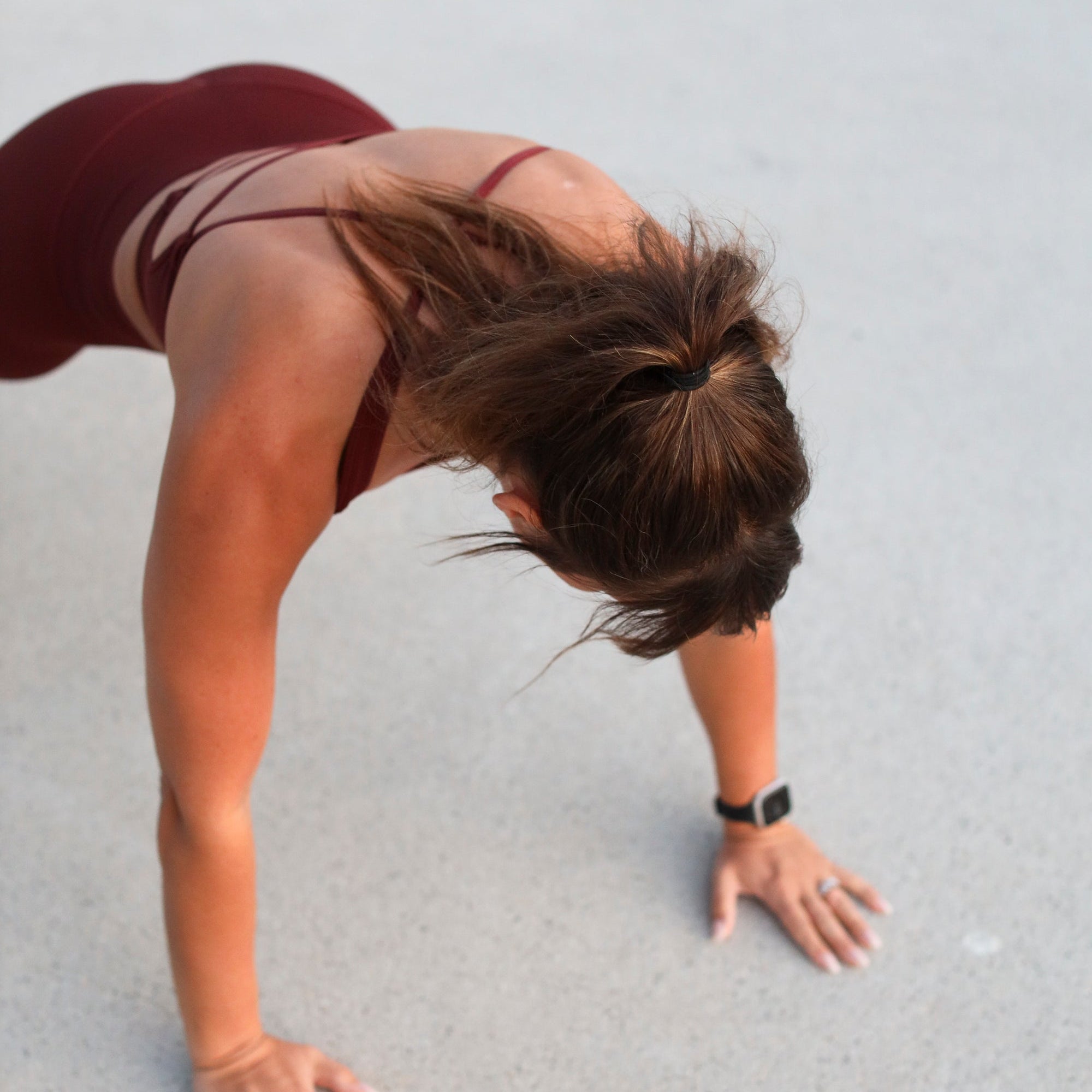 Woman in maroon activewear doing a floor exercise