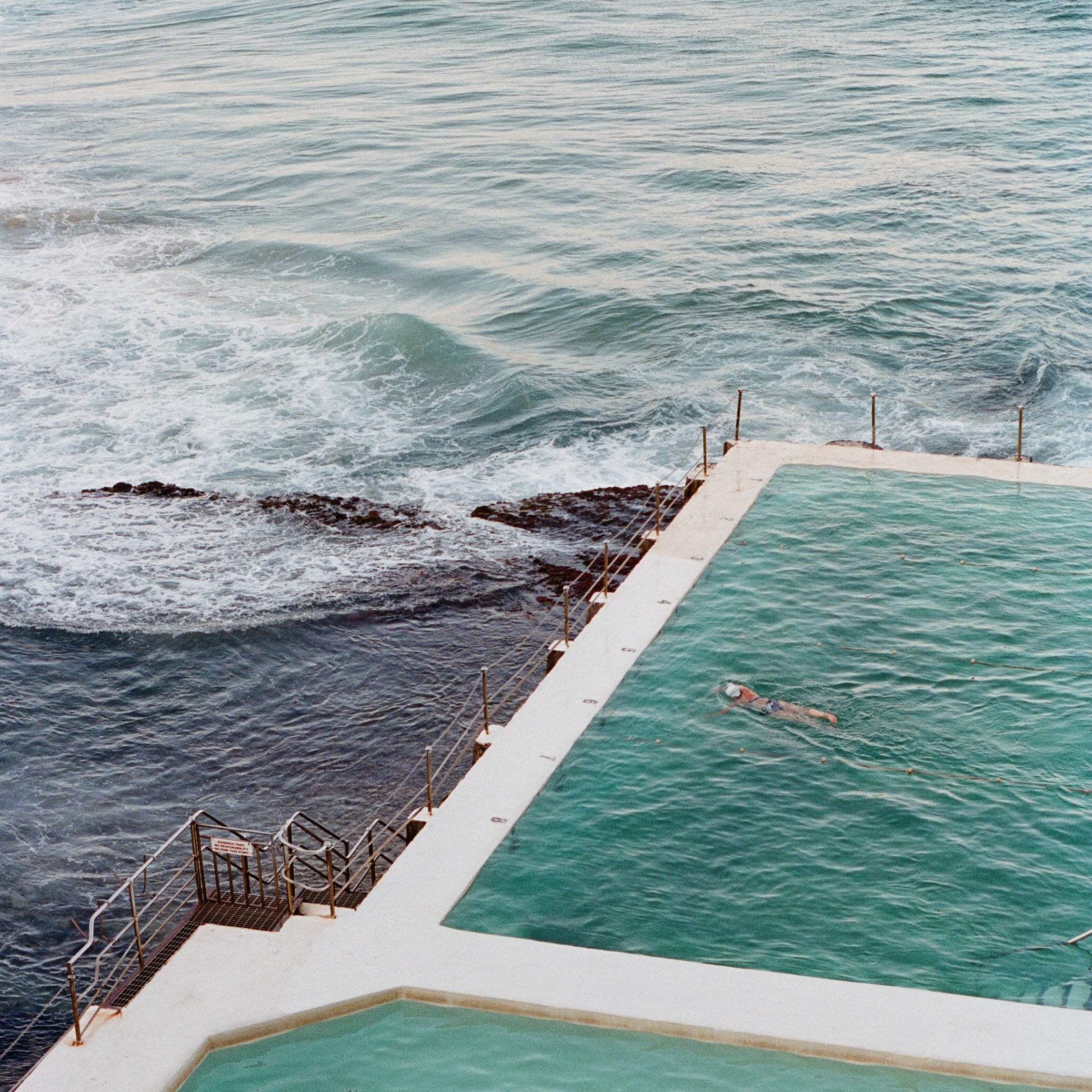 Aerial view of an oceanside swimming pool beside the sea