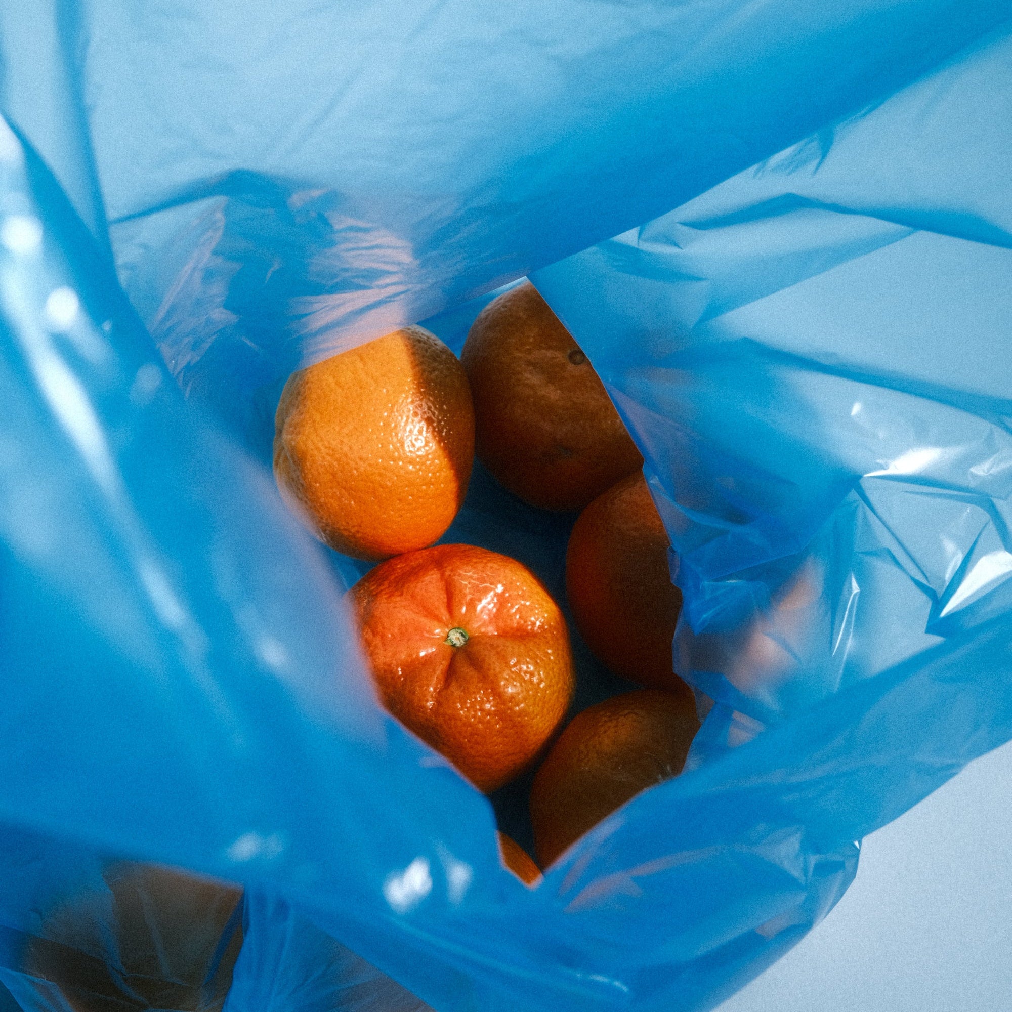 Tangerines in a blue shopping bag