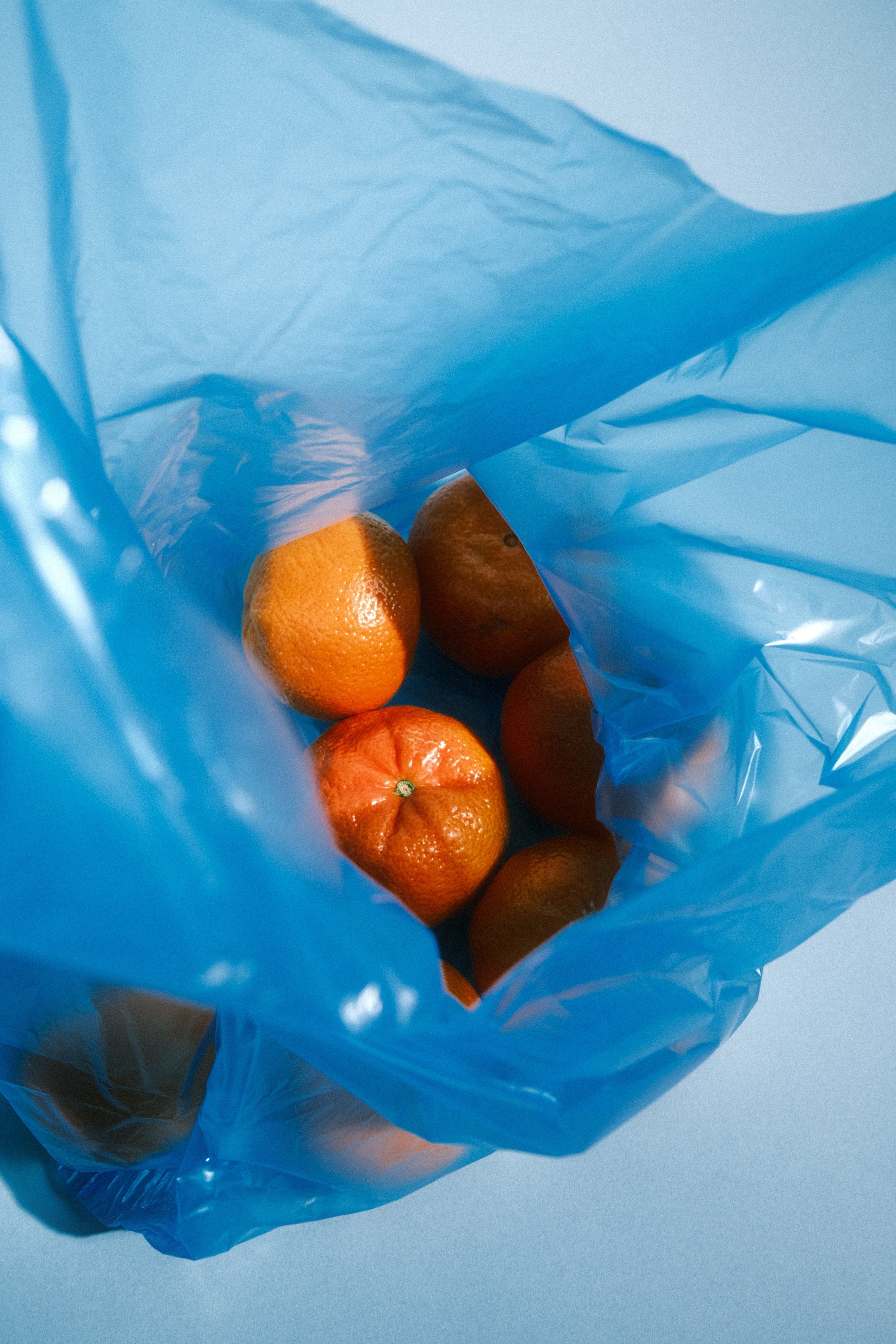 Tangerines in a blue shopping bag