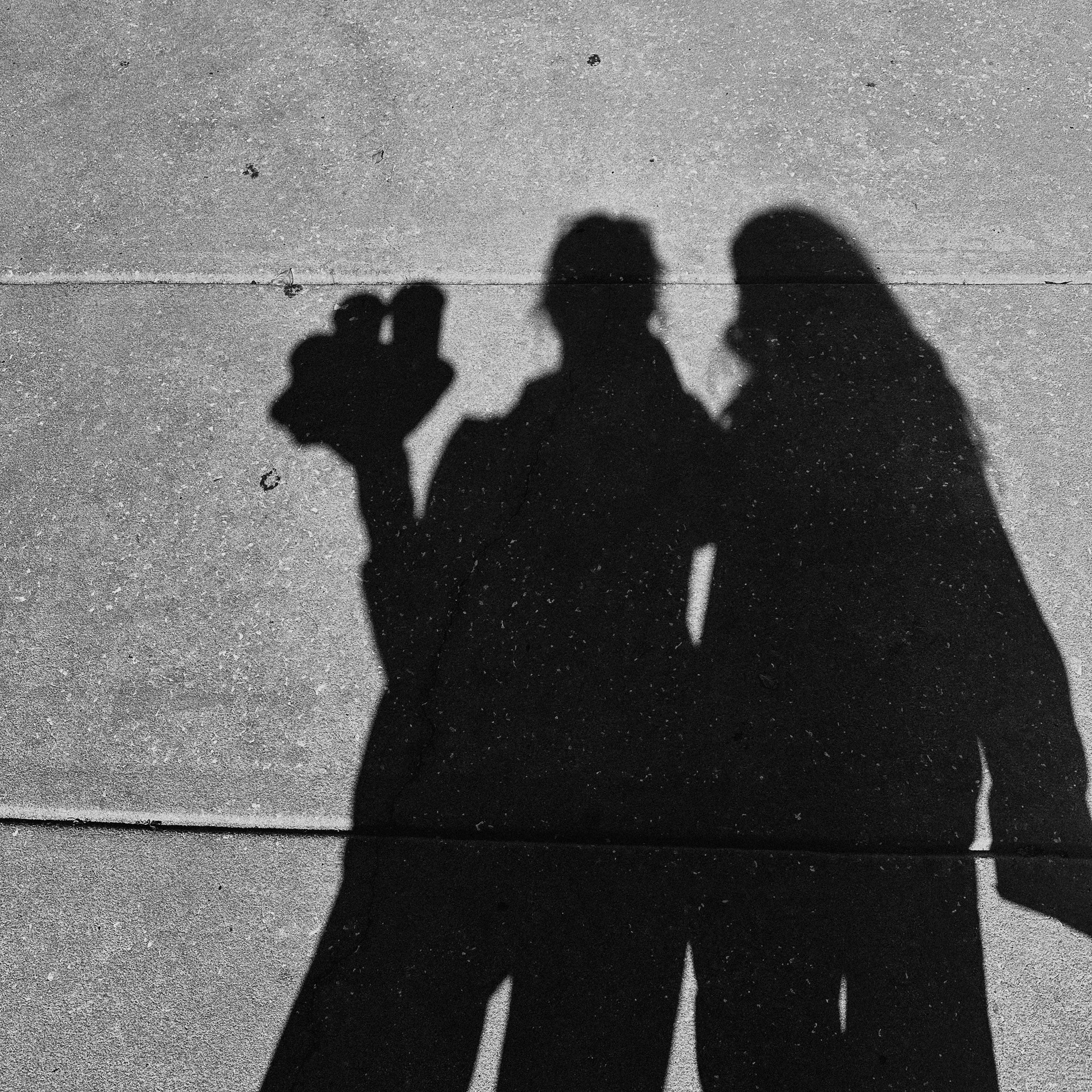 Silhouette shadows of two children cast on the pavement
