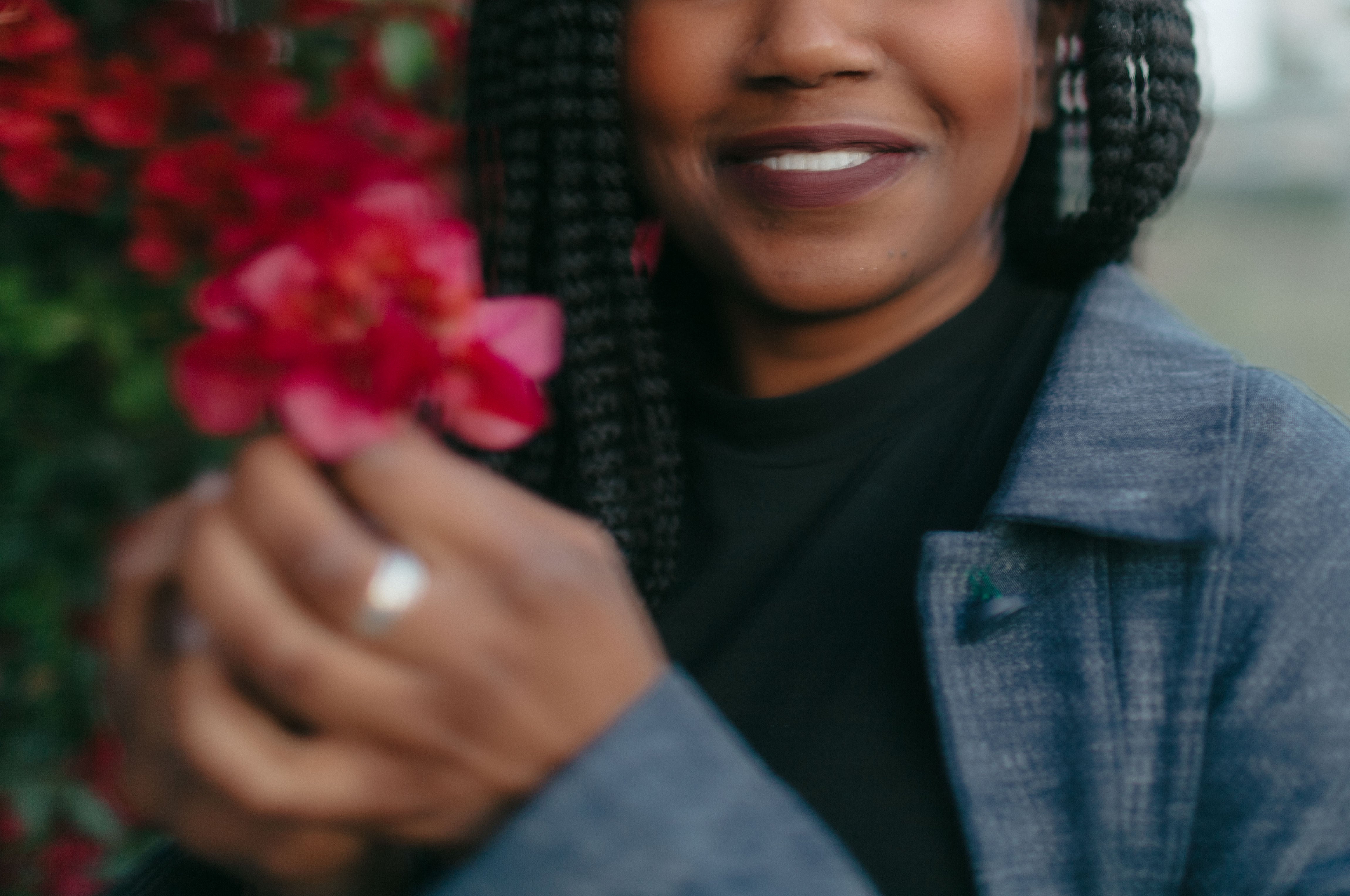 Smiling woman holding a red flower, glowing hair and skin