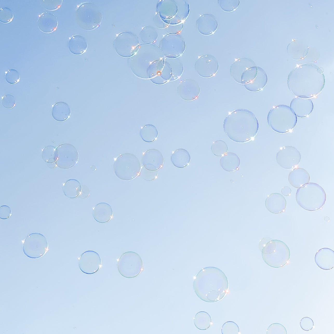 Soap bubbles floating against a blue sky