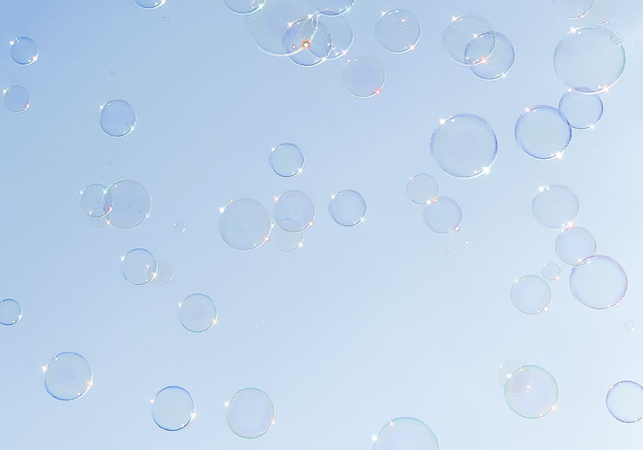 Soap bubbles floating against a blue sky