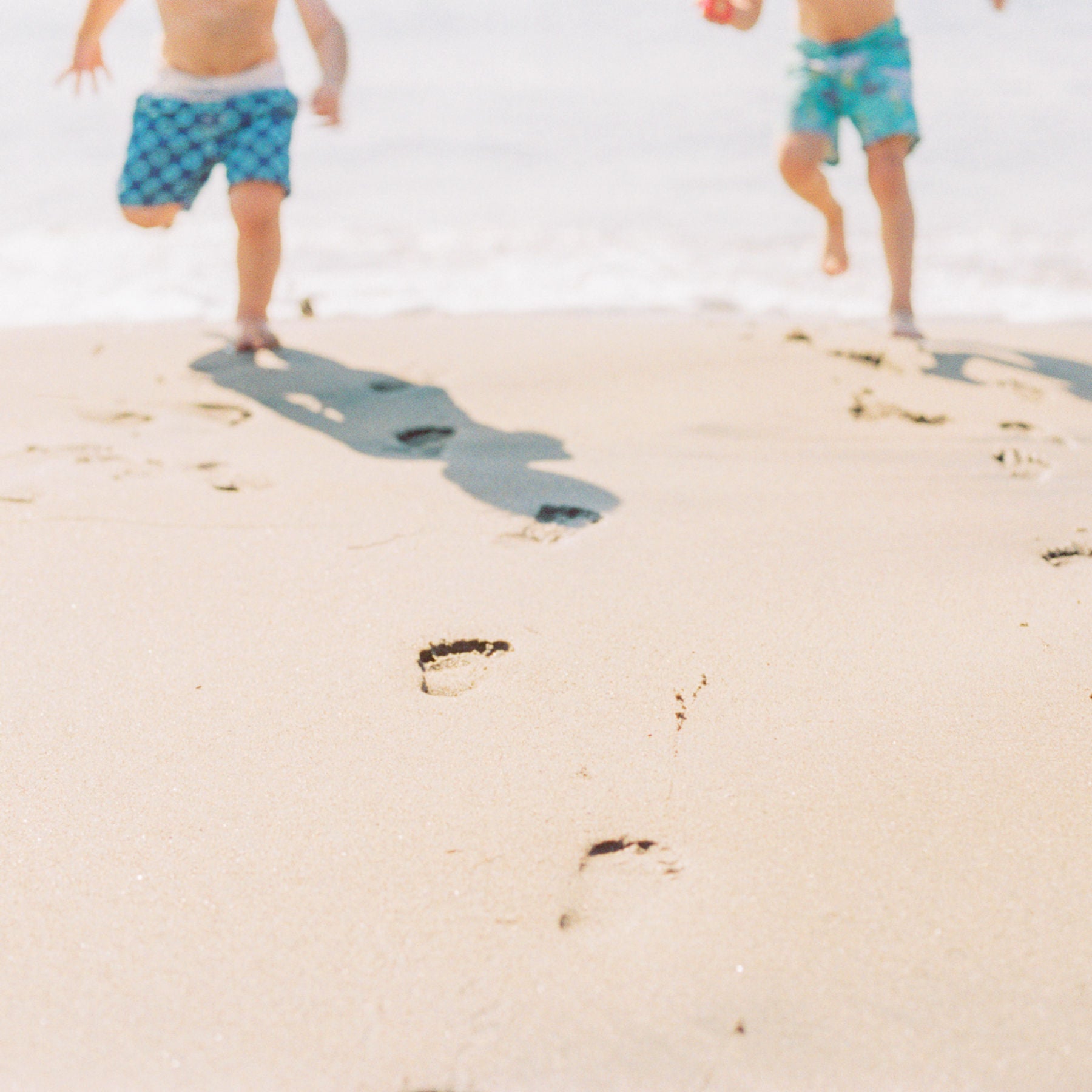 Children running along a sandy beach