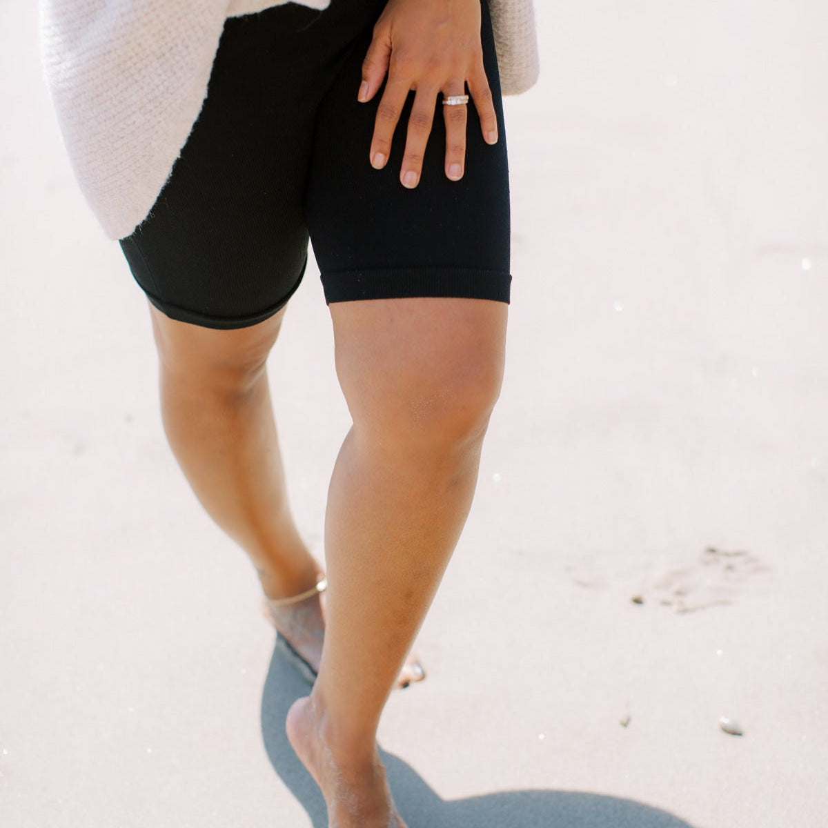 Person walking barefoot across sand