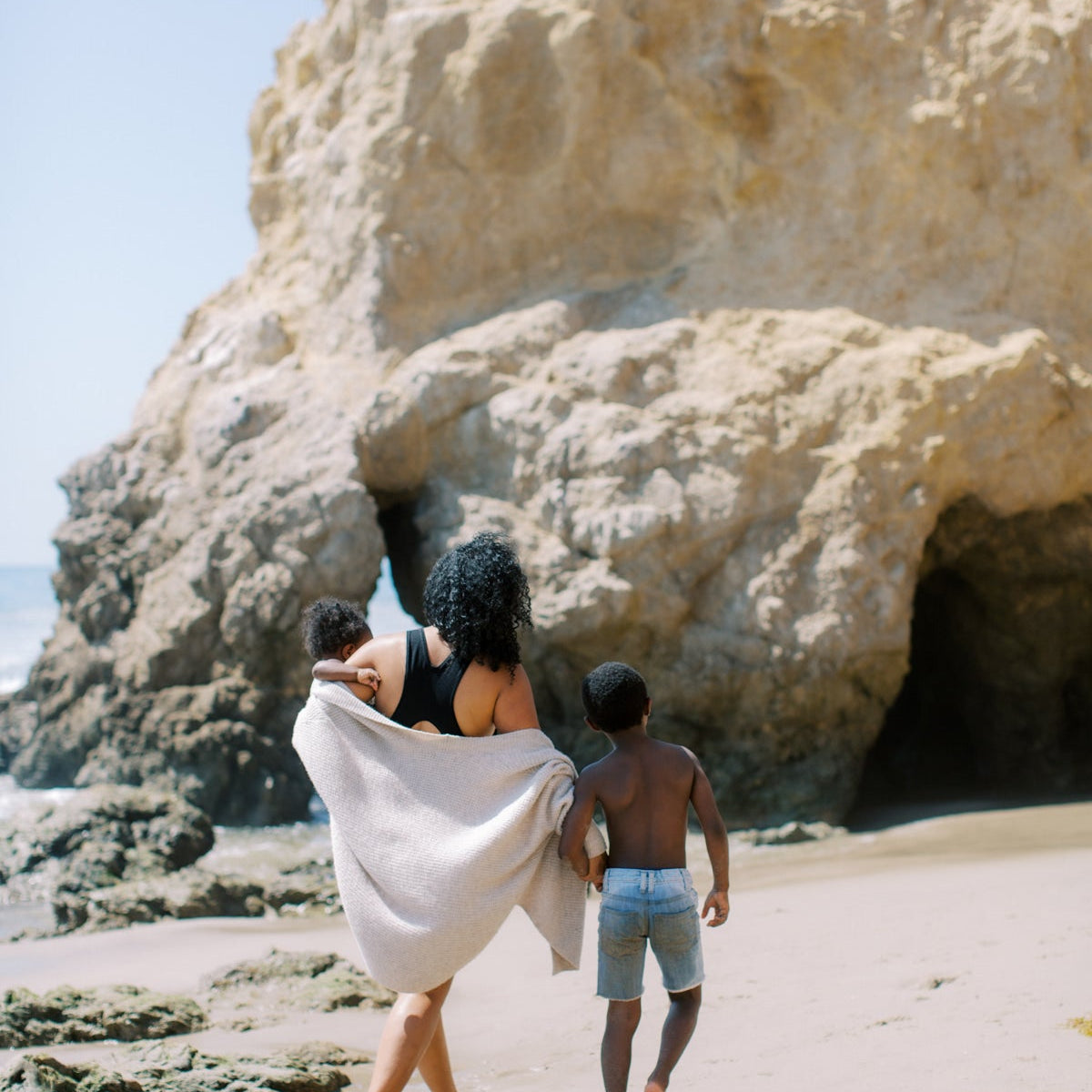 Parent and child walking hand in hand along a beach