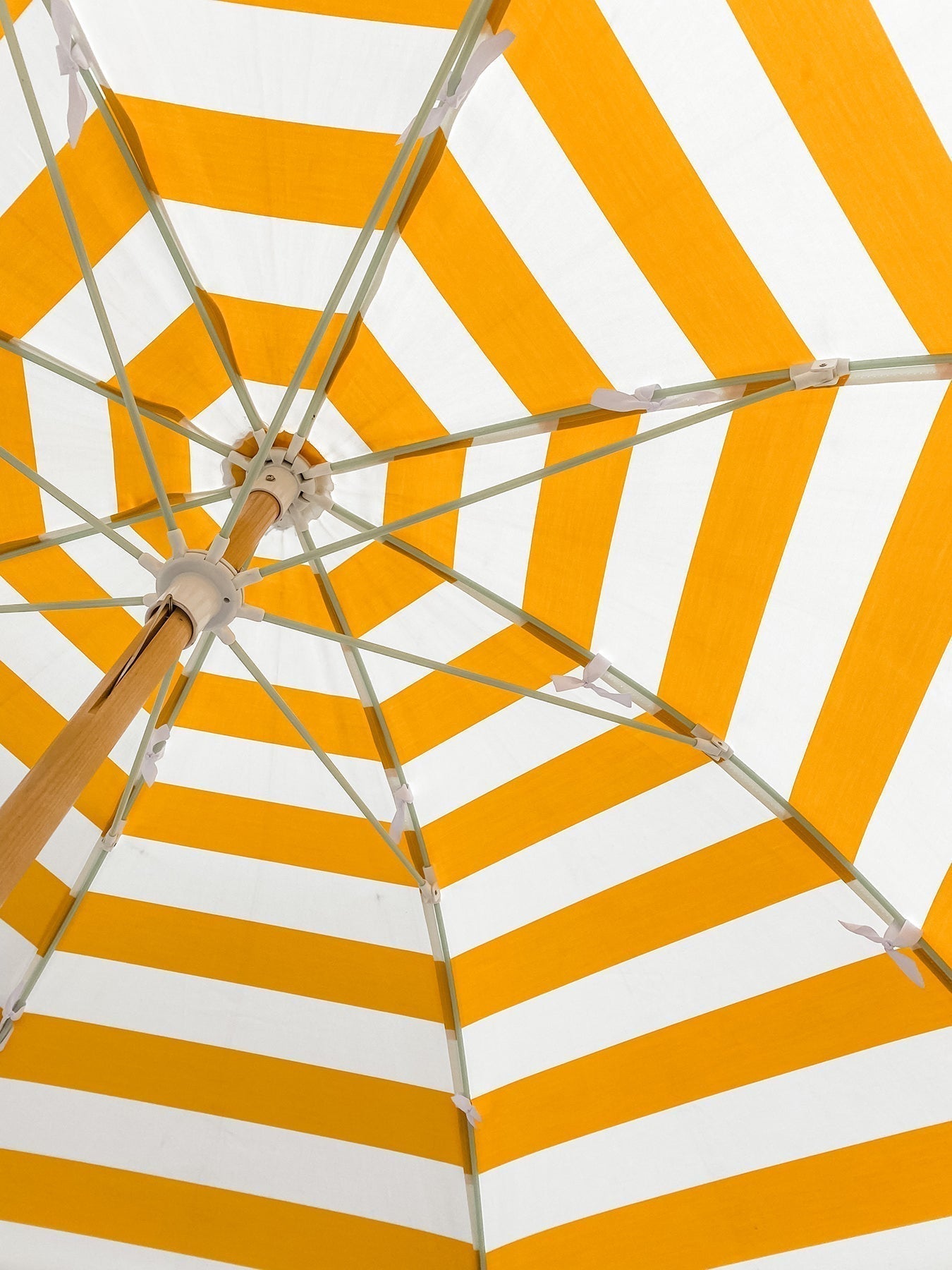 View from underneath an orange and white striped umbrella against the sunlight