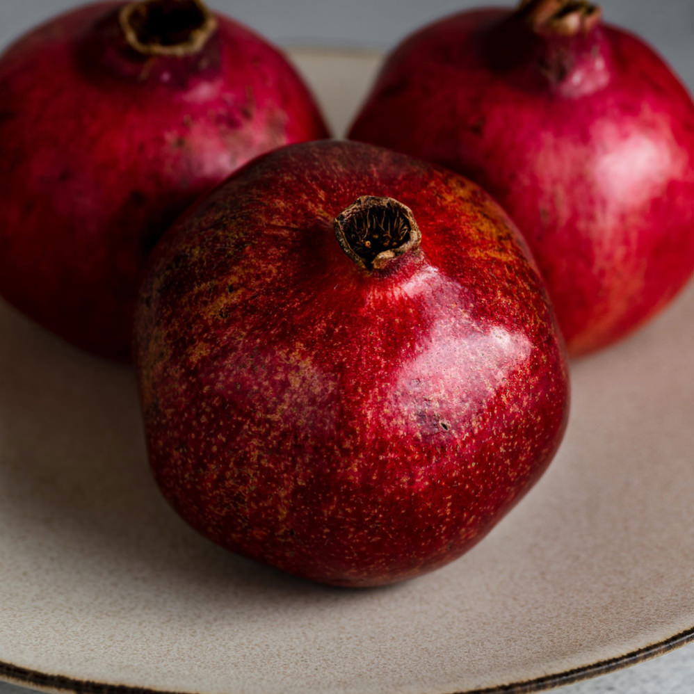 Three pomegranates on a plate