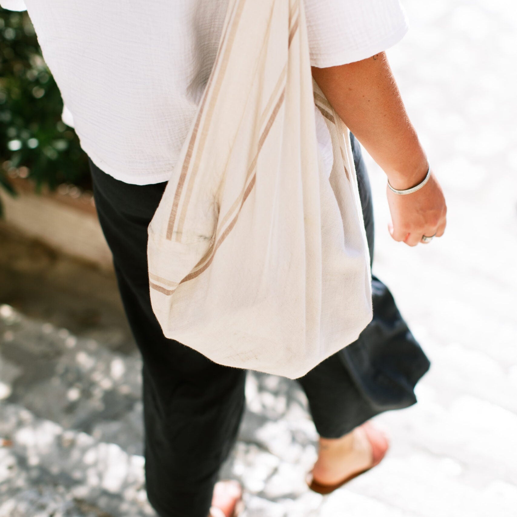 Person walking down steps with a canvas tote bag