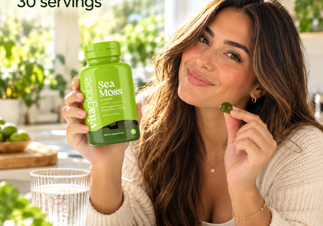 Woman holding a bottle of Vita Globe Sea Moss gummies in a sunny kitchen