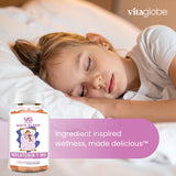 Child sleeping with a bottle of Vitaglobe Kids' Sleep supplement in the foreground.