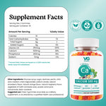 VG Calcium 500 mg gummies packaging graphic showing a bottle of 60 gummies alongside a large white 'Serving Facts' panel with nutritional information, ingredients, and certification badges on a light aqua background.
