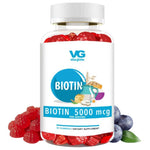 Vita-Globe Biotin supplement bottle with gummy bears and blueberries on a white background