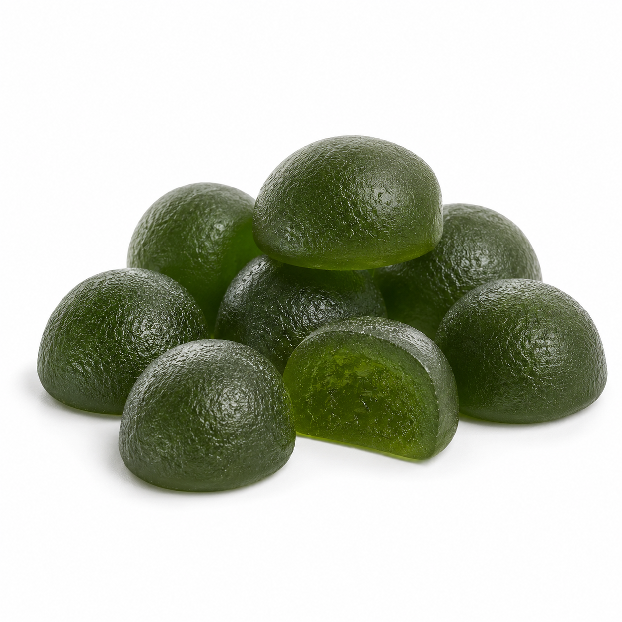 A pile of green, textured, round gelatin candies, with one candy cut in half to show the translucent green filling, set against a plain white background.