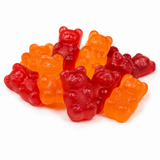 A pile of translucent gummy bear candies in red and orange, photographed on a clean white background.
