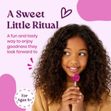 A sweet little ritual: girl holding a Vitalolli Elderberry lollipop, for ages 4+