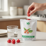 Vita-Green Ashwagandha supplement packaging with raspberries on a kitchen counter.