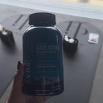 Hand holding a bottle of VitaPower Sugar-Free Creatine Monohydrate Gummies at a Pilates studio