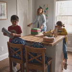 Back-to-school morning in a family kitchen with kids packing up and Vita Globe Vitalolli Vitamin C lollipops on the counter