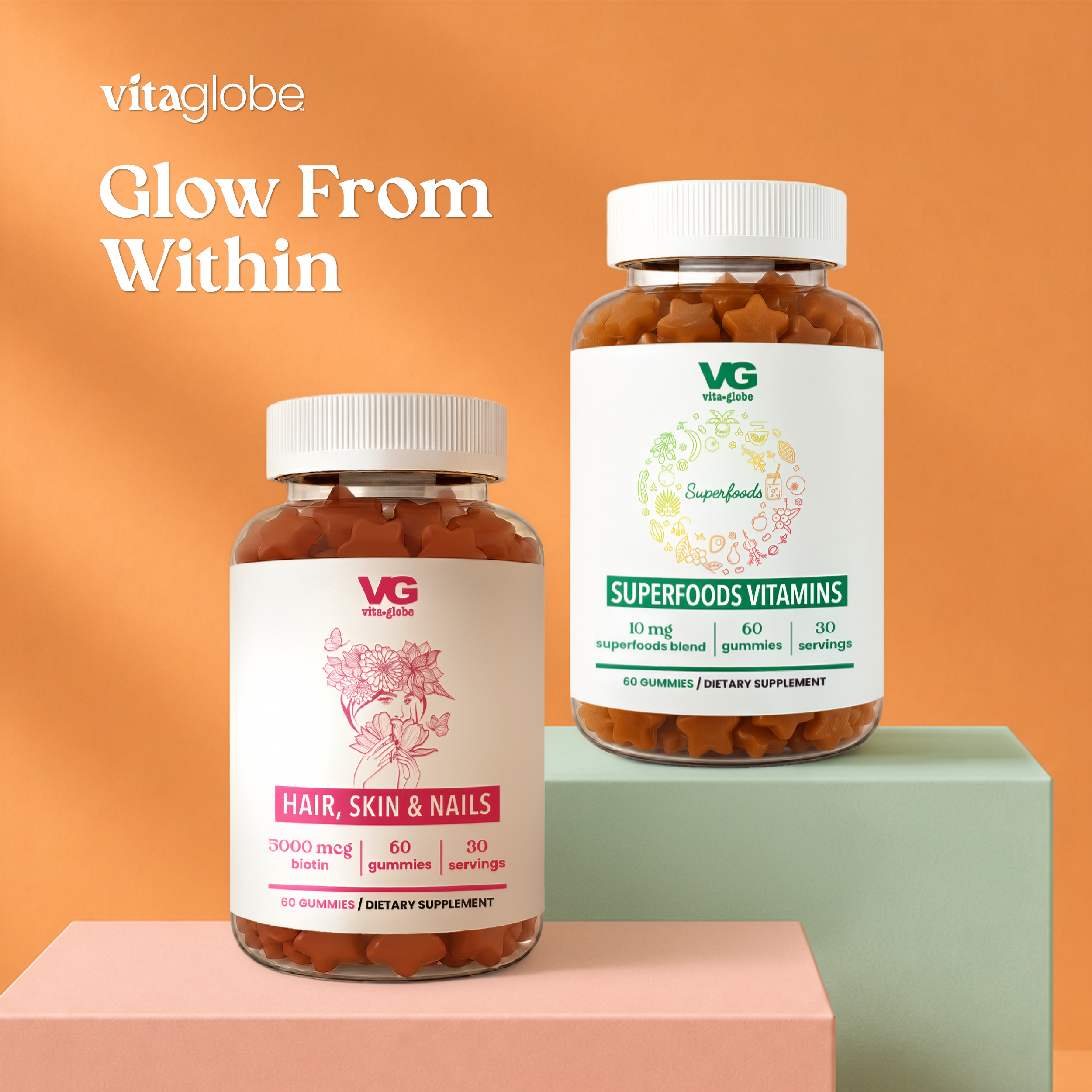 Two bottles of VG vitaglobe Superfoods Vitamins dietary supplements displayed on pastel pink and mint green pedestals against a warm orange background. The left bottle is labeled 'Hair, Skin & Nails' and the right bottle is labeled 'Superfoods'.