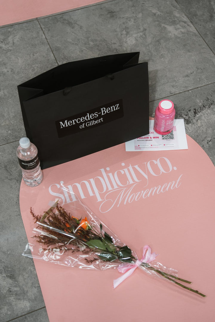 Pink Pilates mat with Vita Globe Her PMS gummies, water and flowers