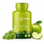 A bottle of vita power by vitaglobe creatine gummies in tart green apple flavor, styled with green gummies, a whole green apple, and a sliced green apple on a white background.