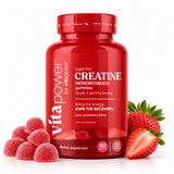A red bottle of vita power Creatine Monohydrate gummies, flanked by fresh strawberries and sugar-coated gummies on a clean white background.